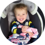Child seated in car seat smiling