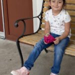 Young child sitting outdoors supported by Give Hope Nevada